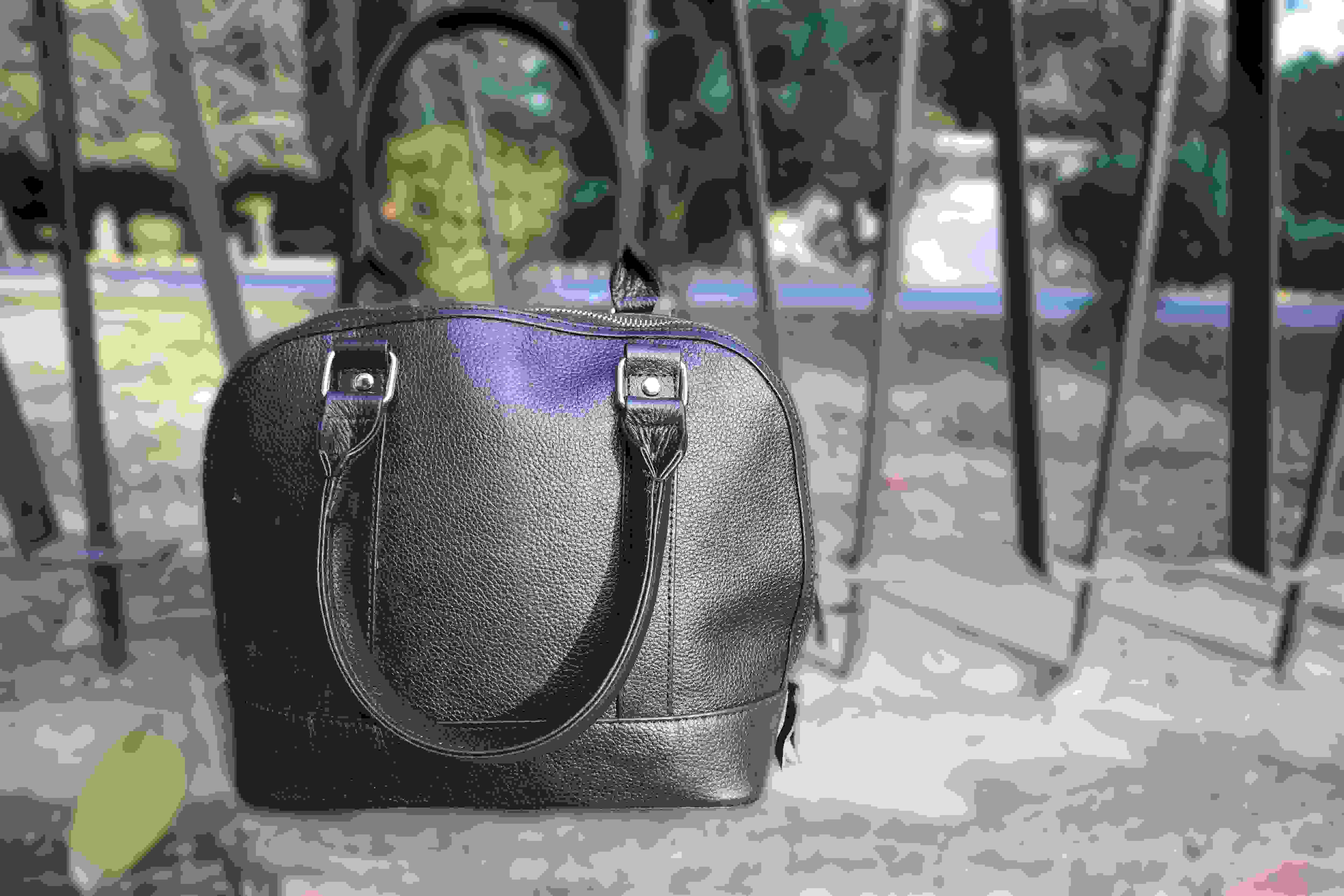 Black handbag with a reflective surface on a textured background