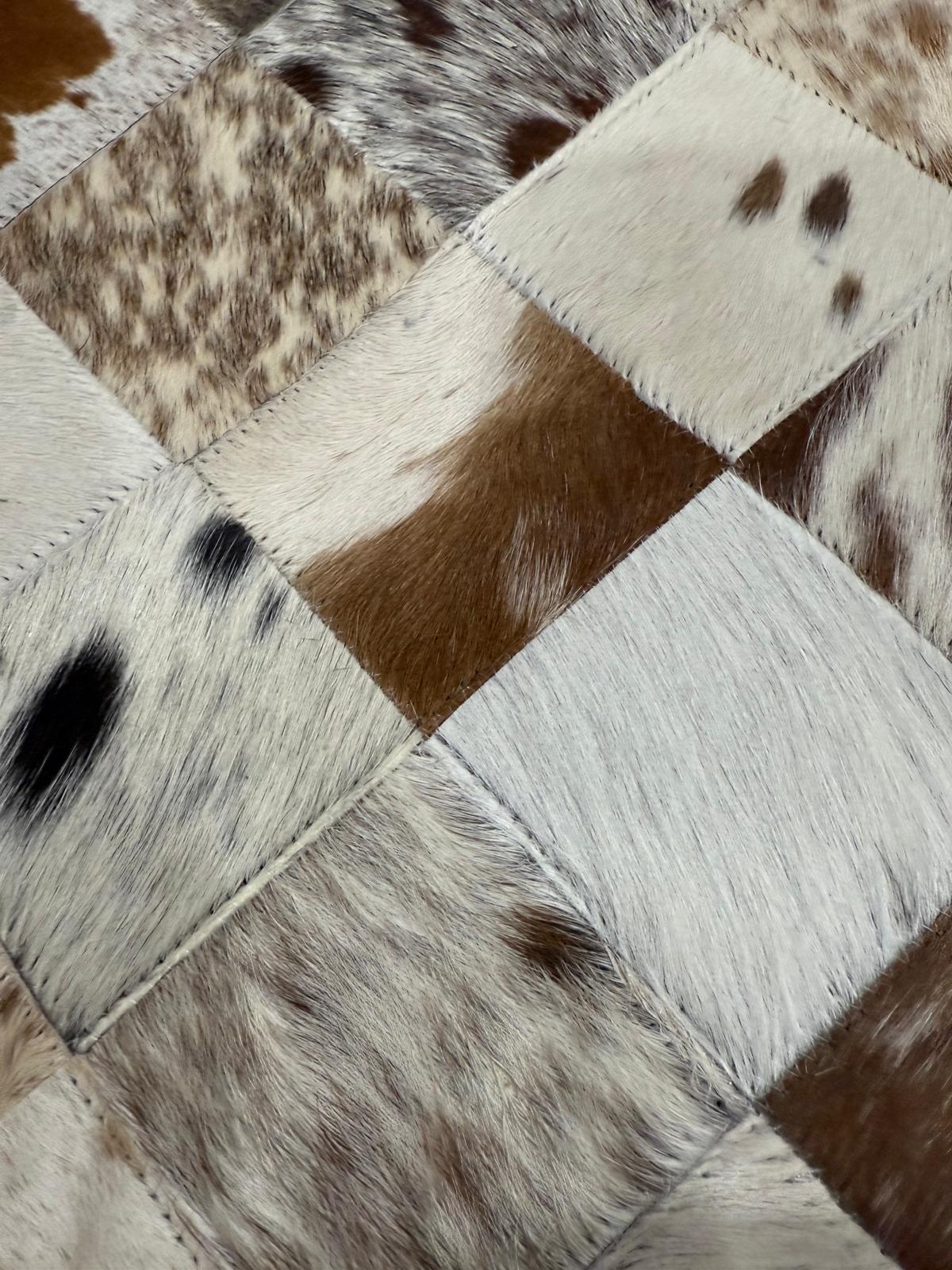 Patchwork of brown, white, and black cowhide leather with a diamond pattern.