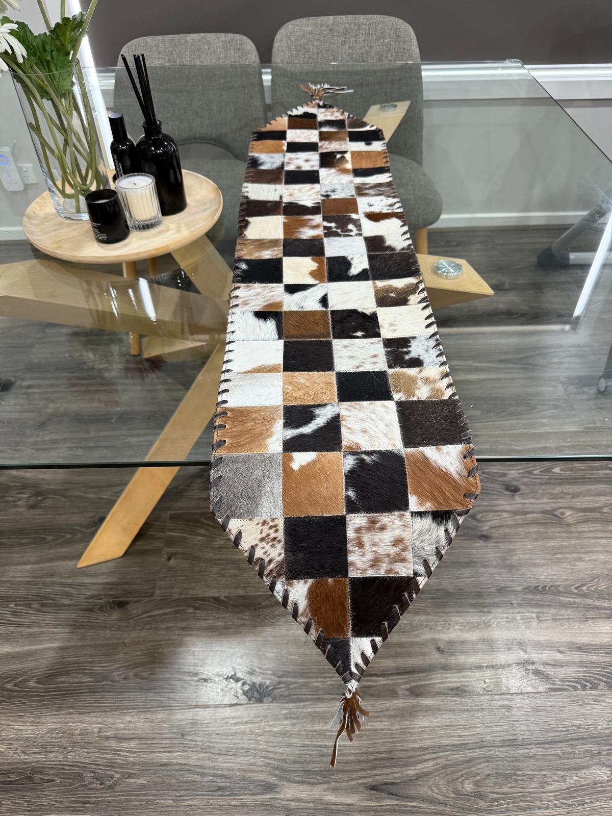 Checkered cowhide table runner on a wooden dining table