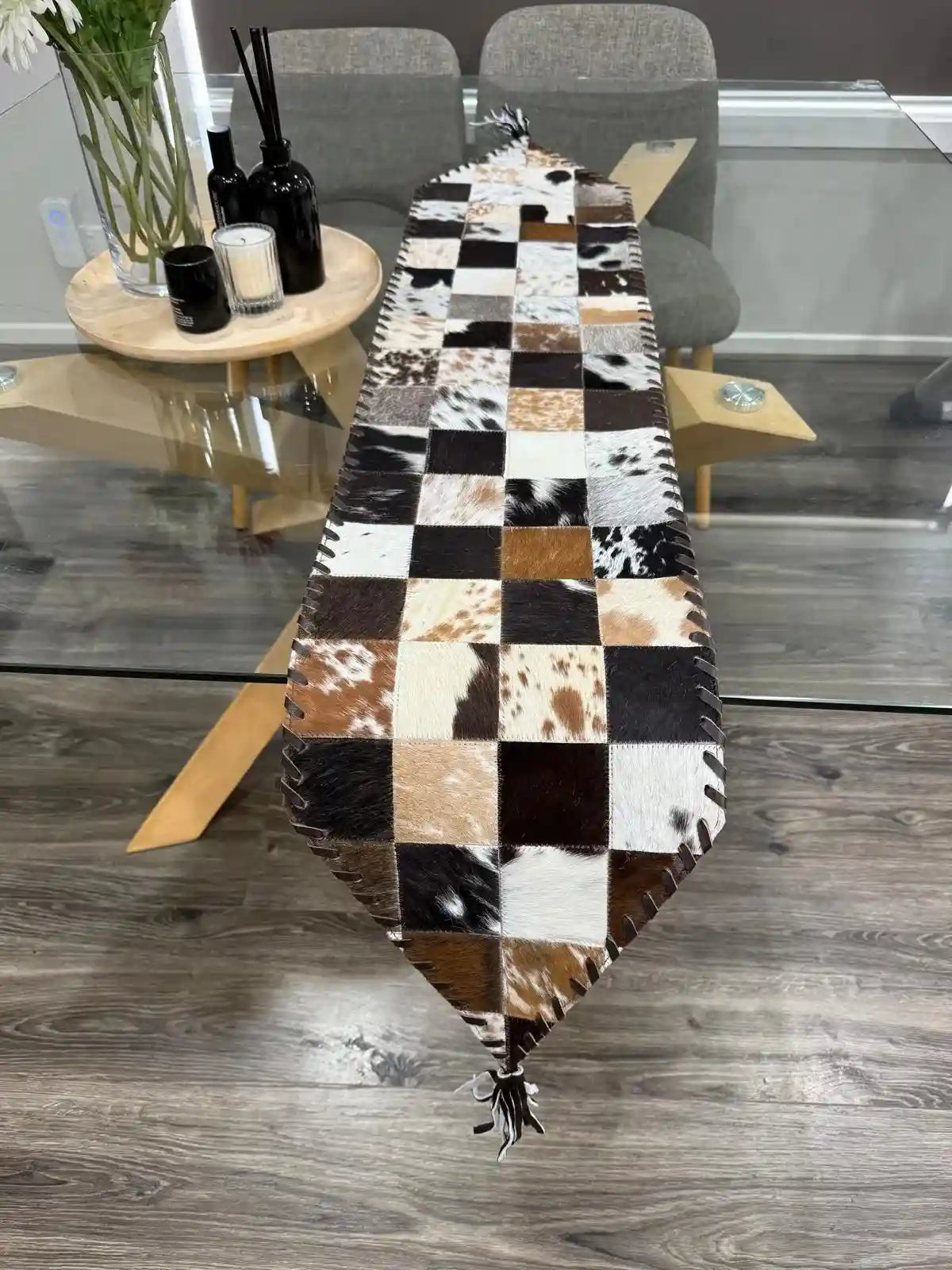 Checkered cowhide rug on a wooden floor with a modern interior setting.