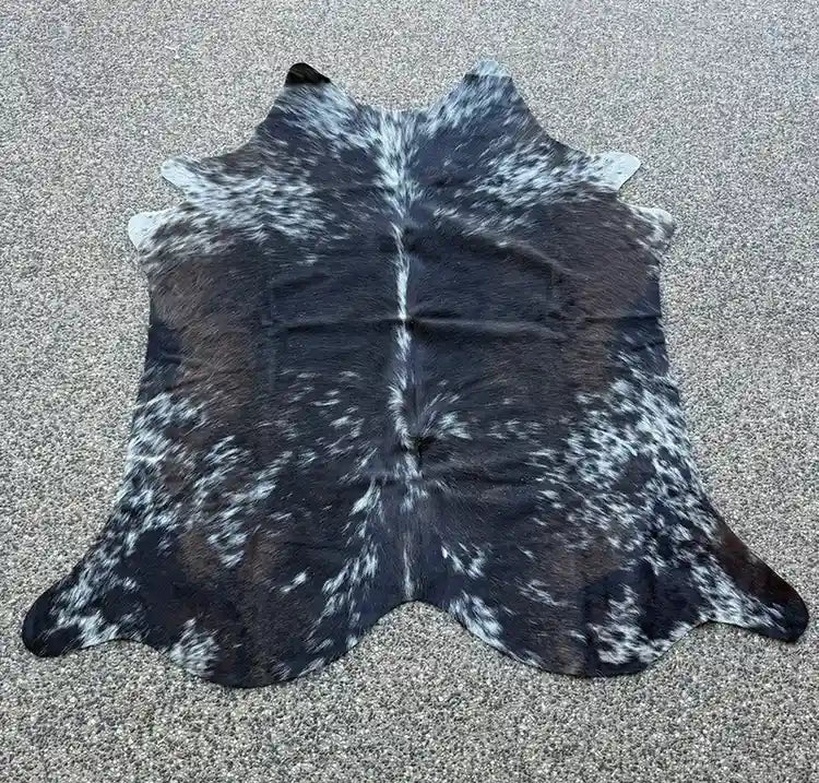 Black and white cowhide rug on a textured surface