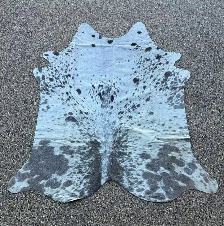 Cowhide rug with black and white pattern on a gray surface