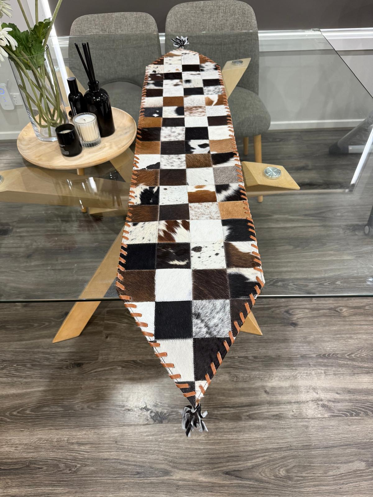 Checkered table runner on a glass dining table with chairs in the background