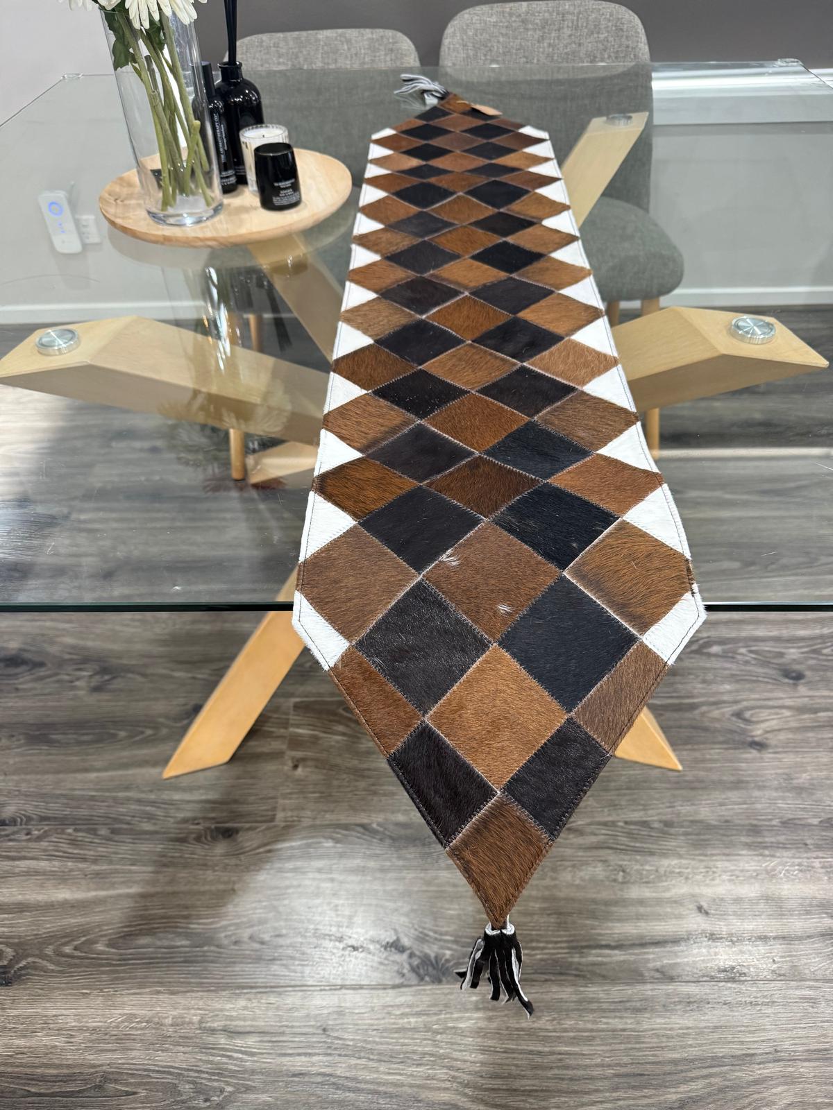 Checkered table runner on a glass table with a wooden floor background