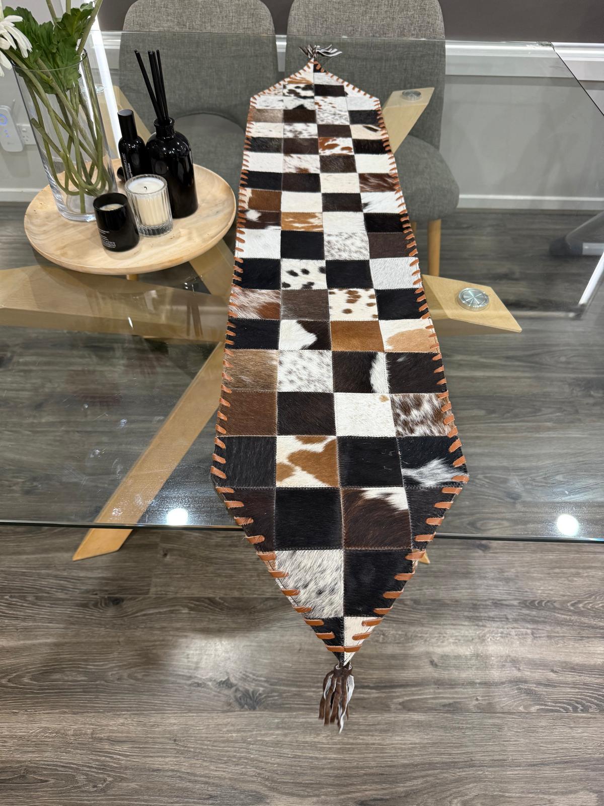 Checkered cowhide rug on a wooden floor with a modern interior setting.