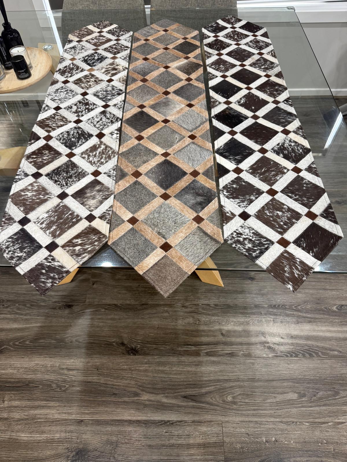 Three patterned table runners on a wooden surface