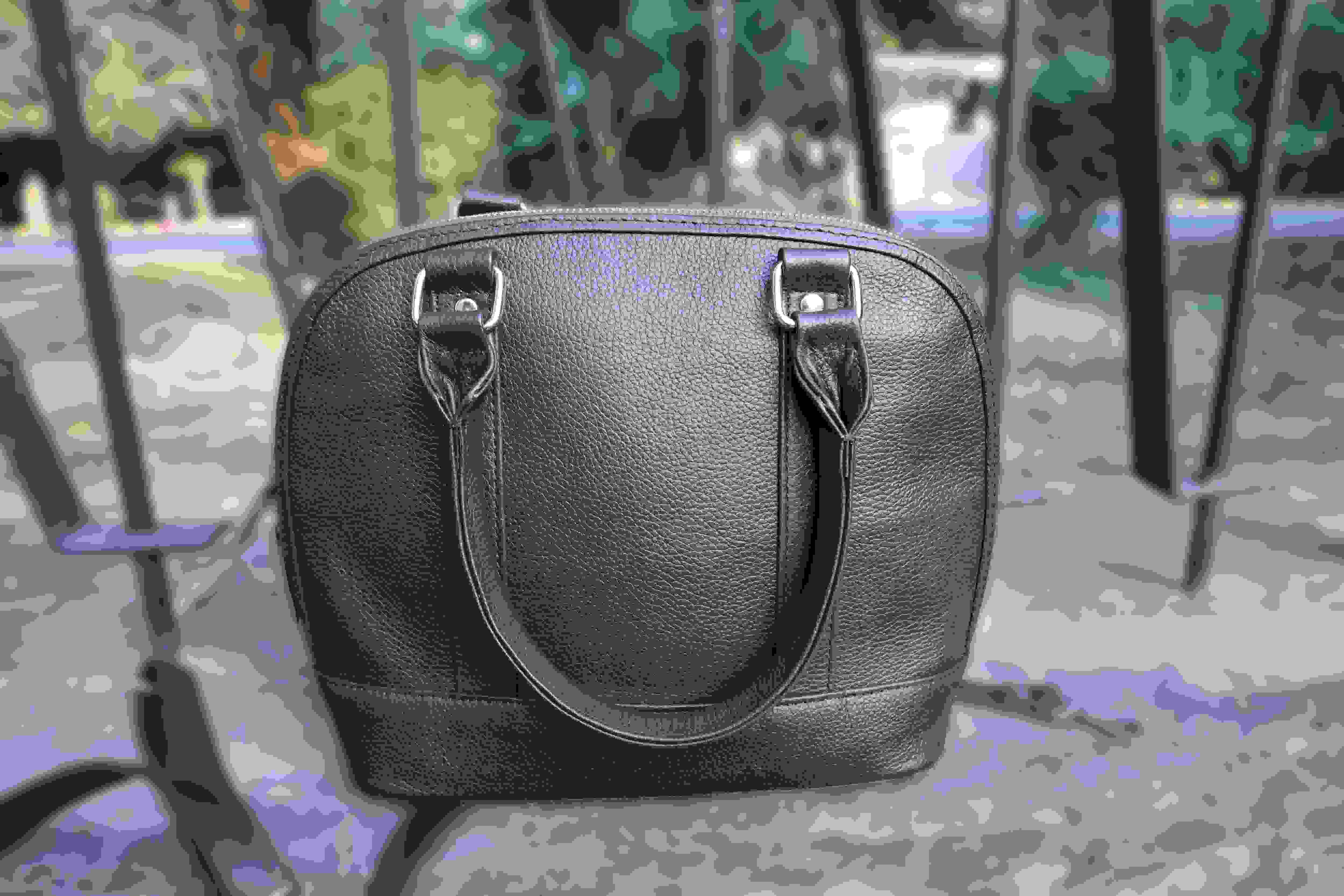 Black handbag on a camouflage-patterned surface