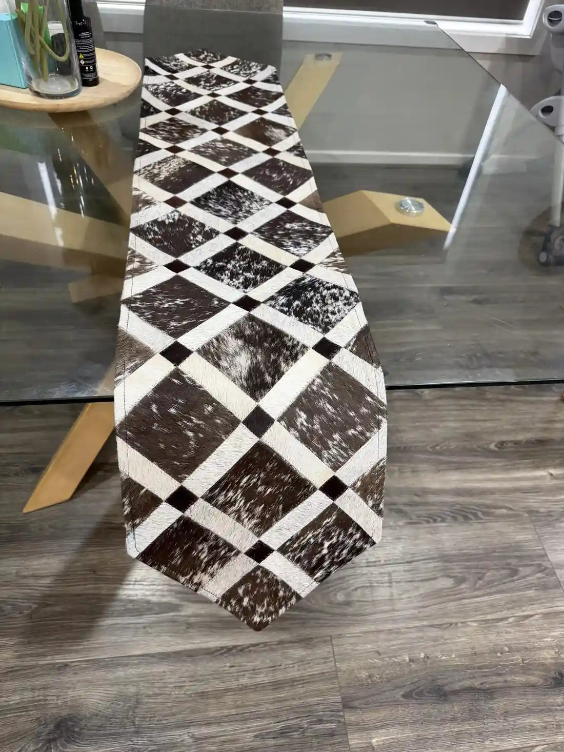 Table runner with black and white diamond pattern on a wooden floor