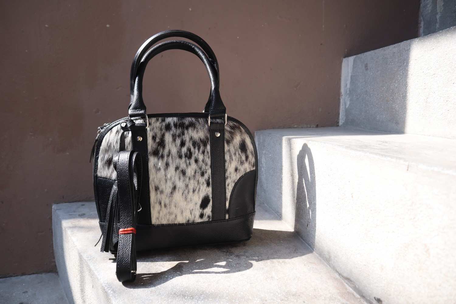 Handbag with black and white pattern on a stone surface