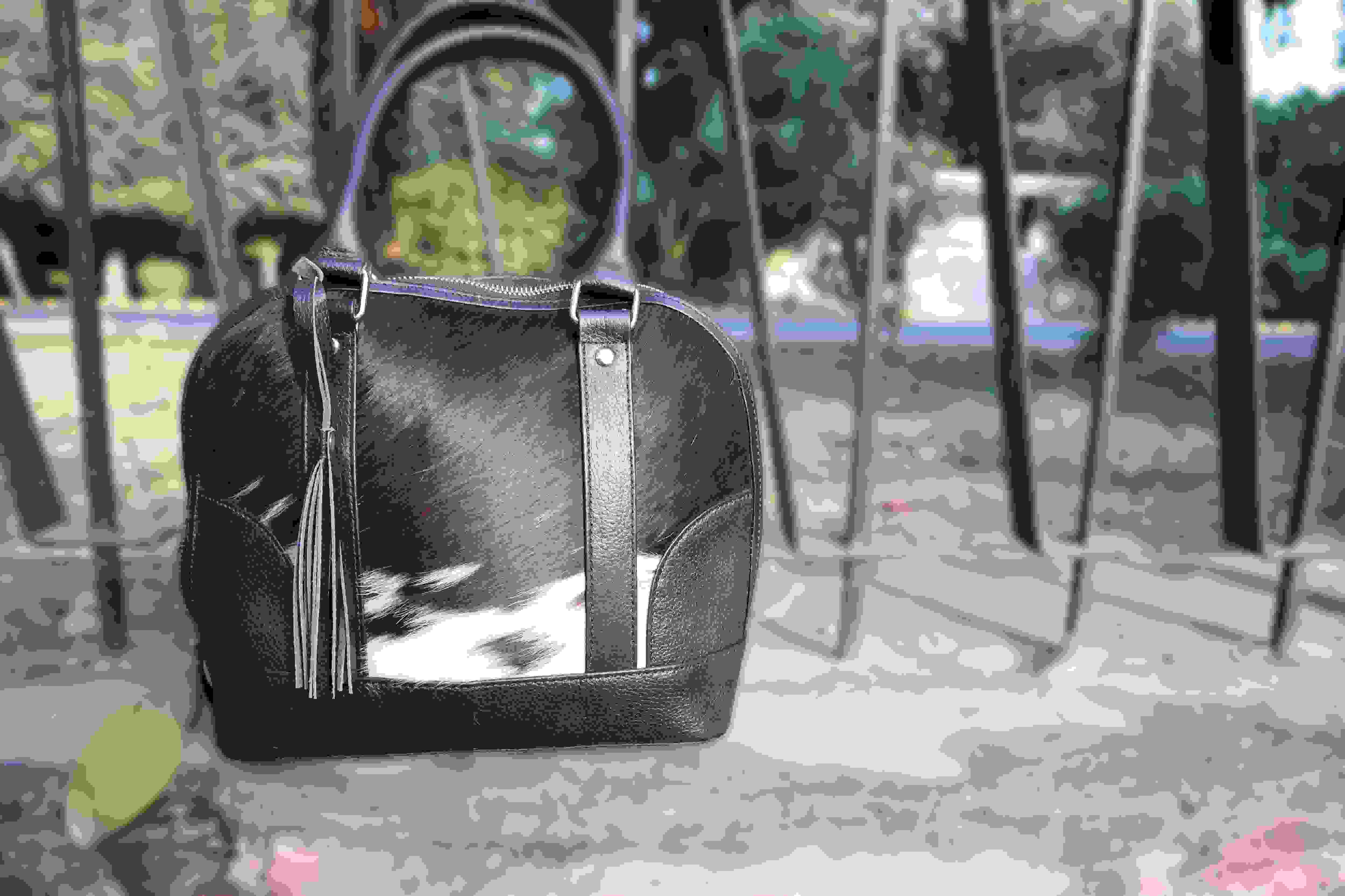 Black handbag with a reflective surface on a textured surface