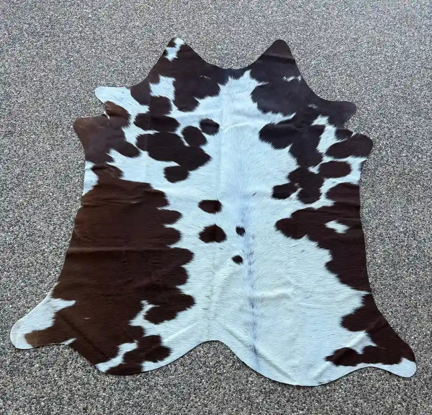 Cowhide rug with brown and white pattern on a gray surface