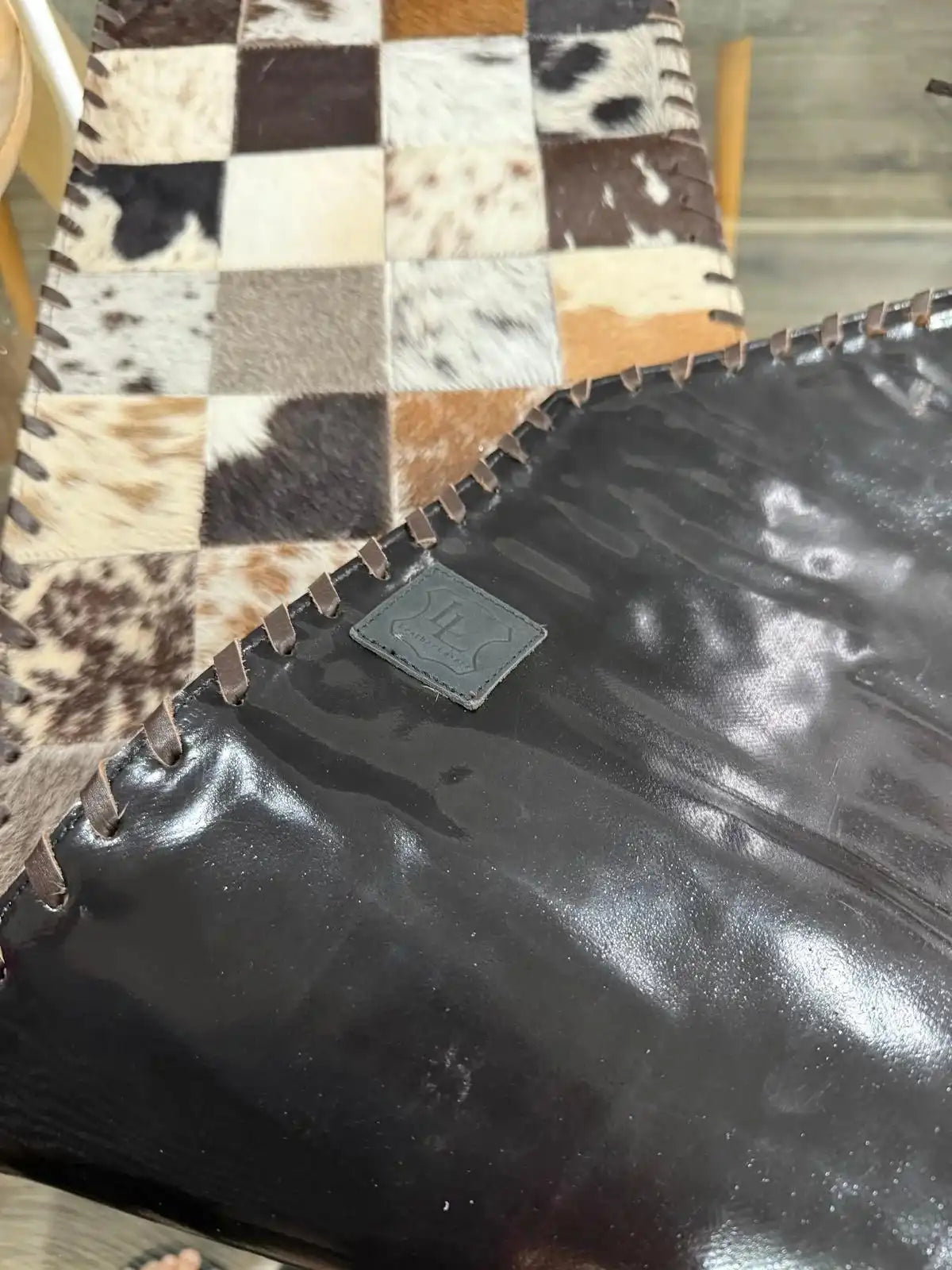 Black leather bag with a brand logo on a checkered fabric background