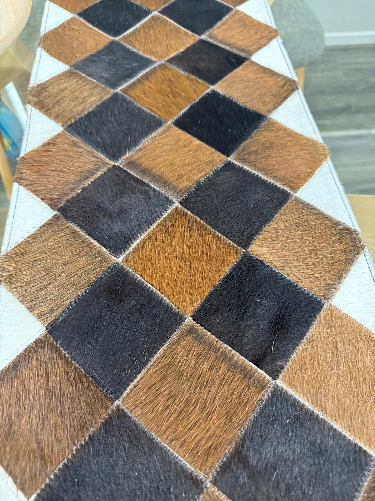 Checkered pattern of brown and black squares on a textured surface.